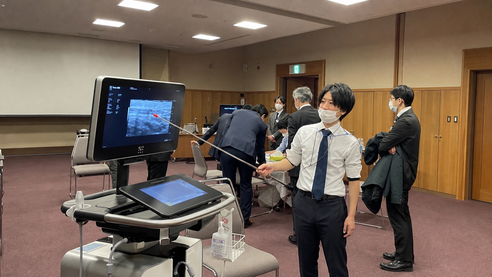 超高周波超音波講習会で、モニタを指しながら指導する辛川領